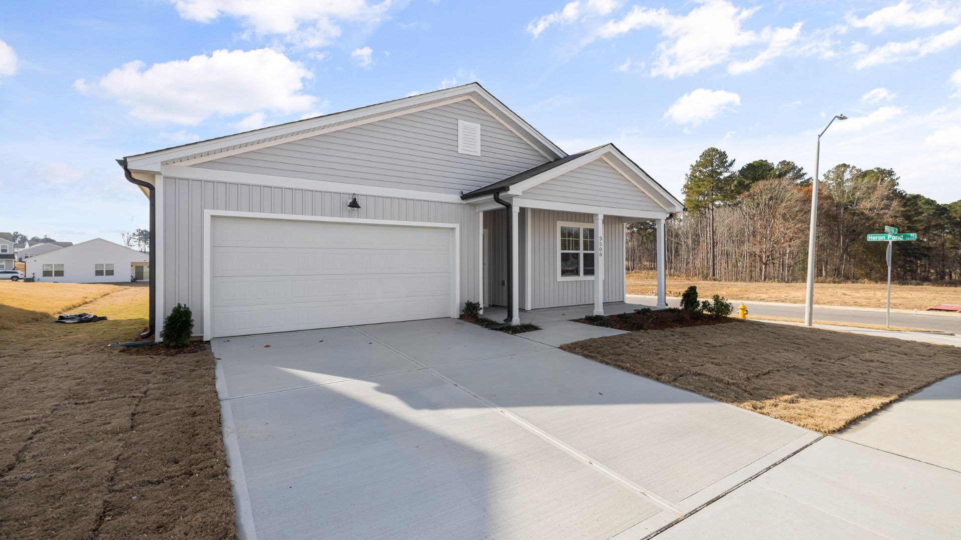 New white single-story house with two-car garage and concrete driveway